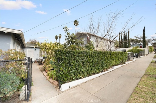 view of property exterior featuring a gate, stucco siding, and fence