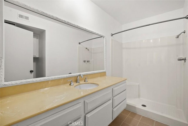 full bathroom with visible vents, walk in shower, vanity, and tile patterned floors