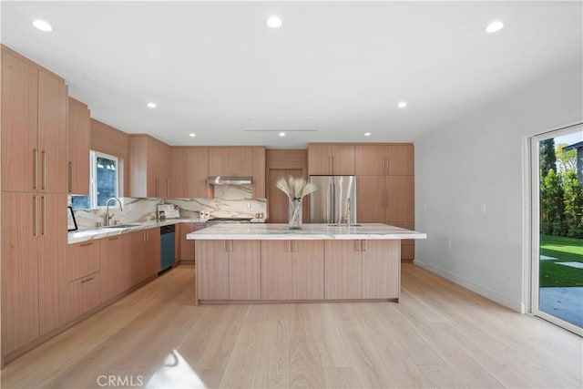 kitchen with sink, a wealth of natural light, a center island, and appliances with stainless steel finishes