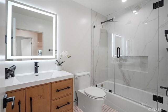 full bathroom with vanity, bath / shower combo with glass door, and toilet