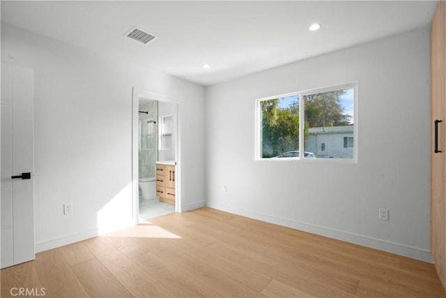 unfurnished bedroom featuring light hardwood / wood-style flooring and ensuite bathroom