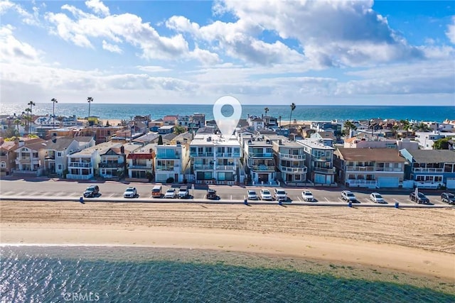 drone / aerial view with a water view and a beach view