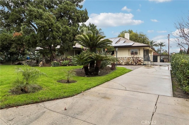 view of front of house featuring a front yard and solar panels