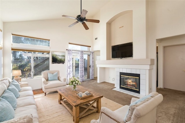 living room featuring light carpet, ceiling fan, a fireplace, and high vaulted ceiling