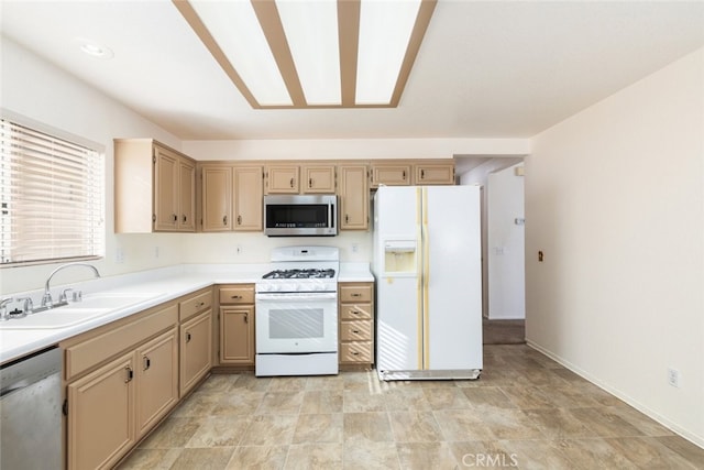 kitchen featuring stainless steel appliances, light countertops, a sink, and baseboards