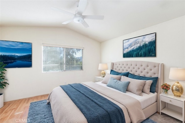 bedroom with light wood-style floors, vaulted ceiling, and a ceiling fan