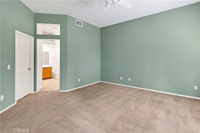 unfurnished bedroom with light carpet, connected bathroom, and ceiling fan