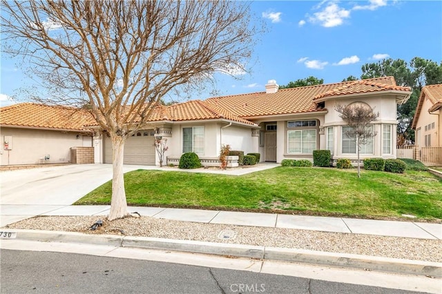 mediterranean / spanish home with a garage and a front lawn