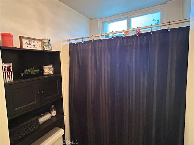 bathroom with a shower with curtain and toilet