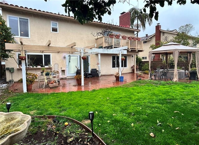 rear view of property with a gazebo, a balcony, a lawn, and a patio area