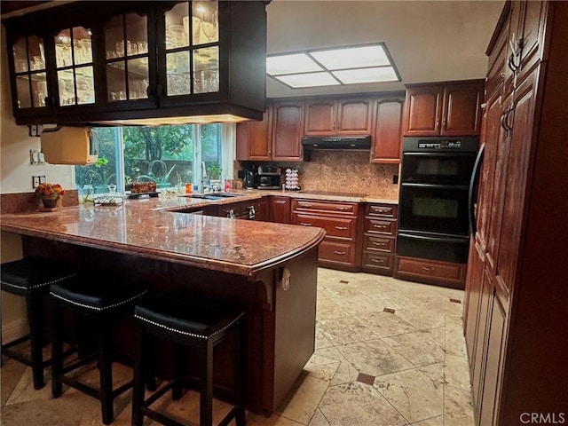 kitchen with black appliances, a kitchen breakfast bar, and kitchen peninsula