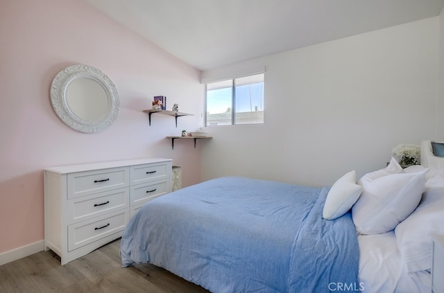 bedroom featuring light hardwood / wood-style floors and vaulted ceiling