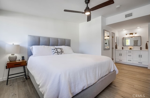 bedroom with light hardwood / wood-style flooring, ceiling fan, and ensuite bathroom