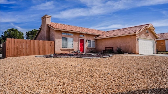 view of front facade with stucco siding, an attached garage, a chimney, and fence