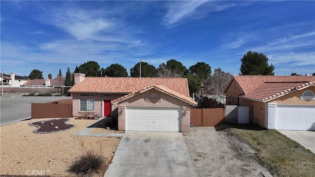 view of front of property with stucco siding, fence, a tile roof, a garage, and concrete driveway