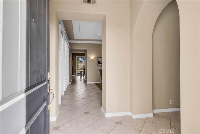 entrance foyer with crown molding and light tile patterned floors