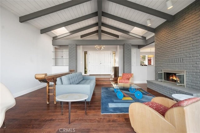 living room featuring a brick fireplace, an inviting chandelier, vaulted ceiling with beams, and dark hardwood / wood-style flooring