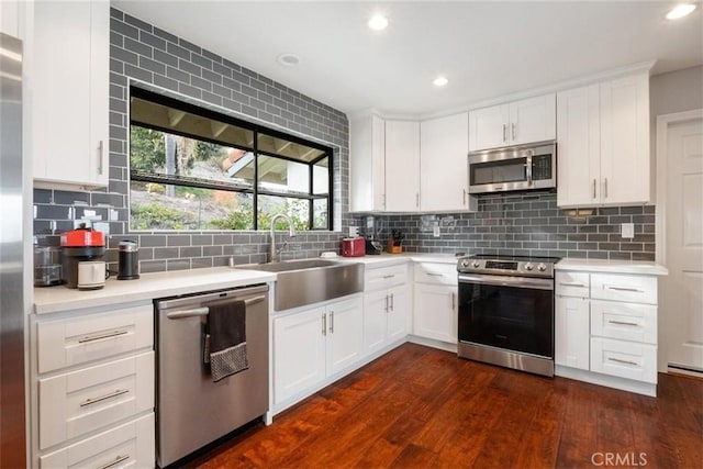 kitchen featuring appliances with stainless steel finishes, sink, dark hardwood / wood-style floors, and white cabinets