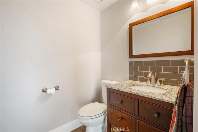 bathroom with backsplash, vanity, and toilet