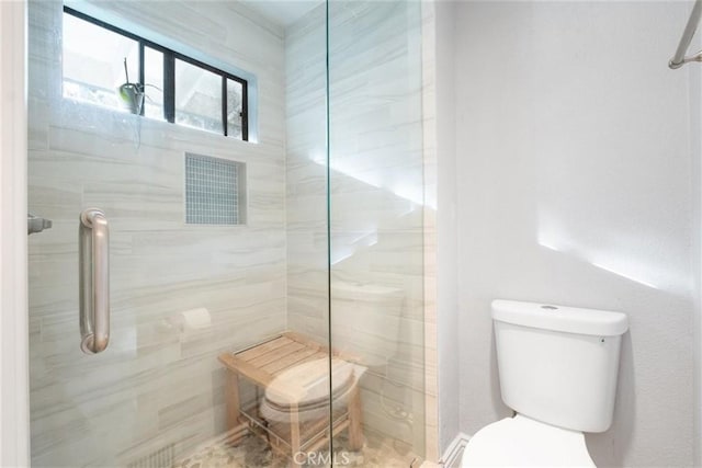 bathroom with toilet and a shower with door