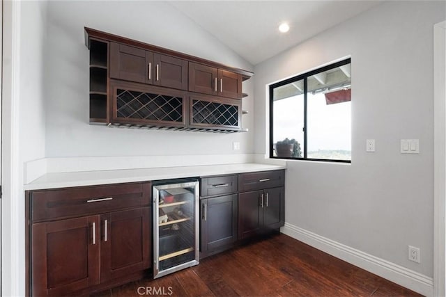 bar with dark hardwood / wood-style flooring, dark brown cabinets, vaulted ceiling, and wine cooler