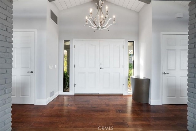 entryway with dark hardwood / wood-style flooring, a chandelier, and vaulted ceiling