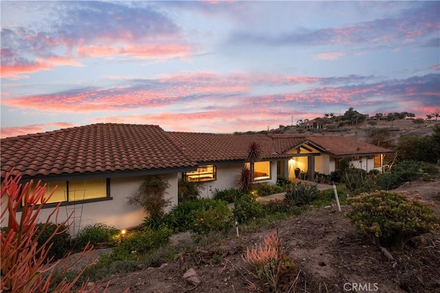 view of front of house with a tile roof and stucco siding