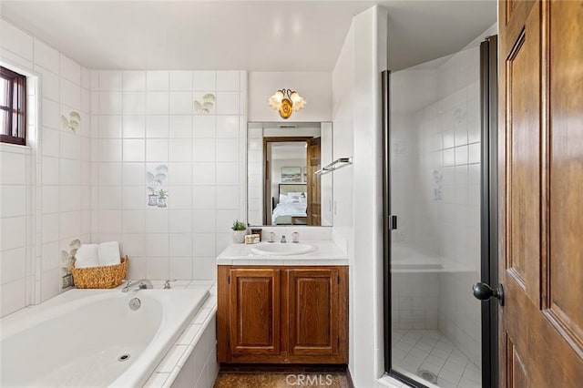 ensuite bathroom with a garden tub, tile walls, a stall shower, vanity, and ensuite bath