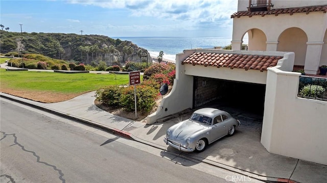 exterior space featuring a garage and a water view