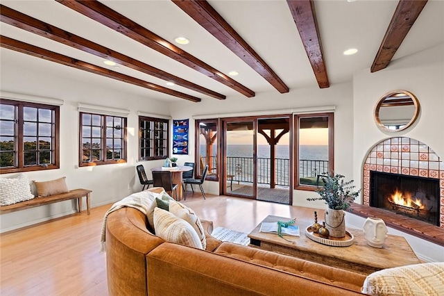 living room featuring a fireplace, recessed lighting, light wood-type flooring, beamed ceiling, and baseboards