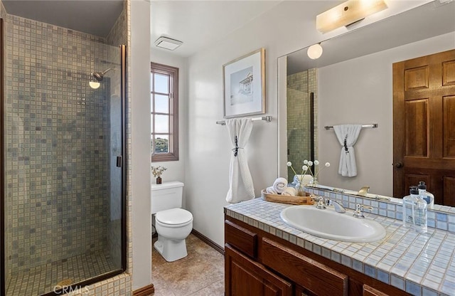 full bath featuring vanity, a shower stall, and toilet