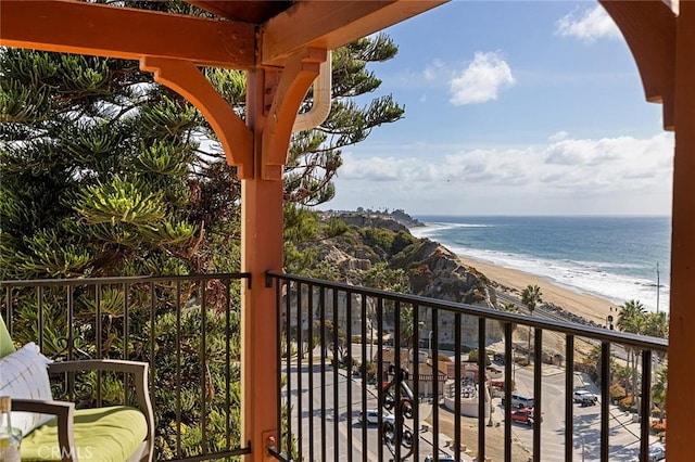 balcony featuring a view of the beach and a water view