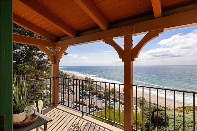 balcony featuring a beach view and a water view