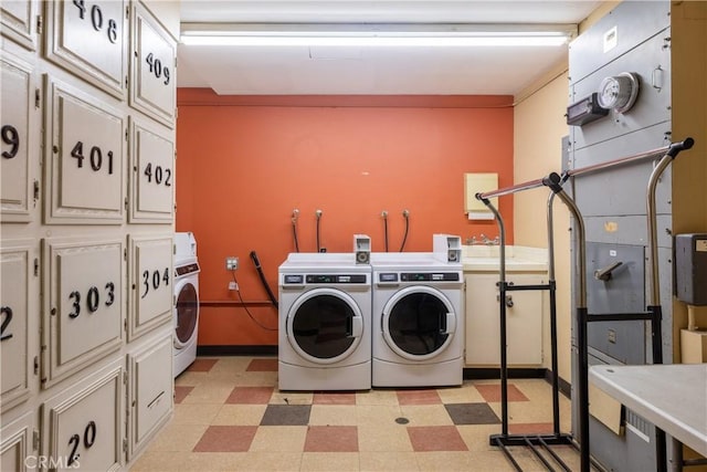 laundry room with washer and clothes dryer and cabinets