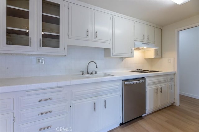 kitchen with white stovetop, sink, stainless steel dishwasher, white cabinets, and backsplash