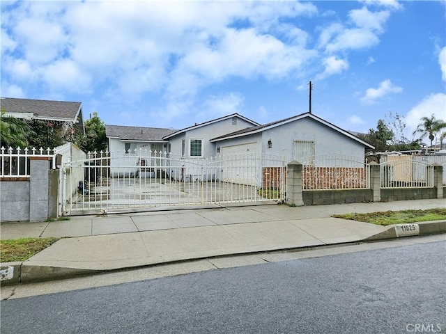 view of front of house with a fenced front yard, a gate, driveway, and a garage