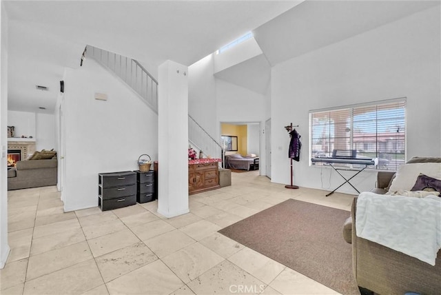 tiled foyer featuring a high ceiling and a fireplace