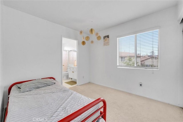 bedroom featuring light carpet and connected bathroom