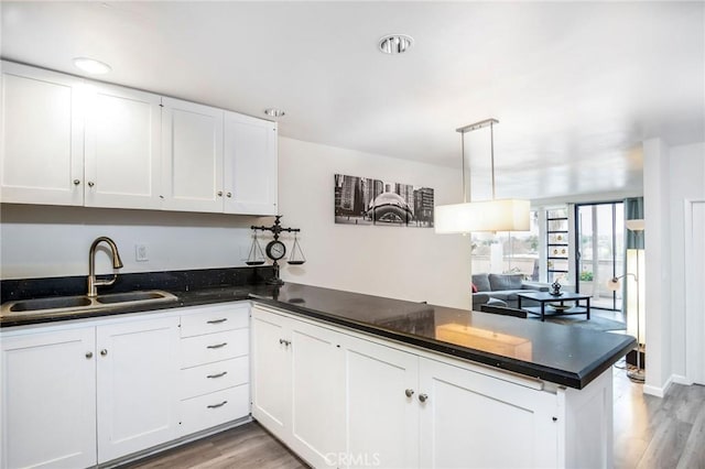2525 E 19th St Unit 12, Signal Hill, CA 90755 - kitchen with a peninsula, white cabinetry, light wood-style flooring, and a sink