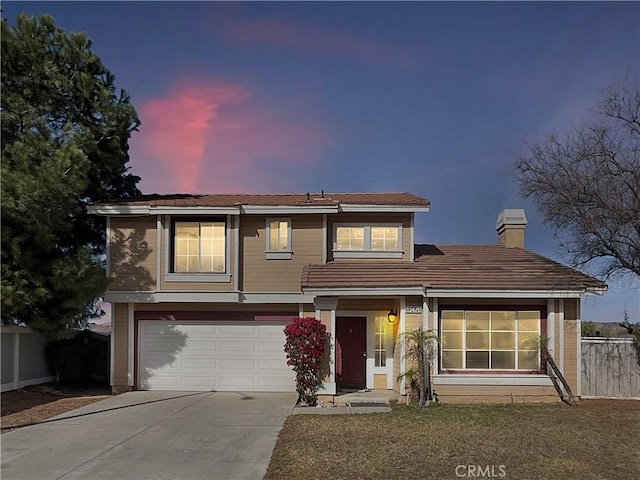 traditional home featuring a garage, a chimney, fence, and driveway