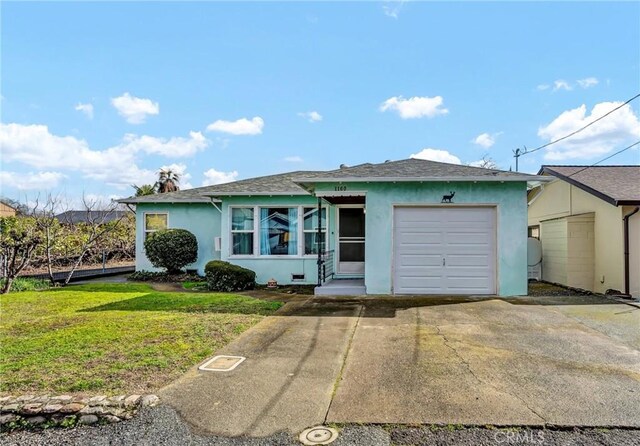 view of front of house featuring a front yard, driveway, an attached garage, and stucco siding