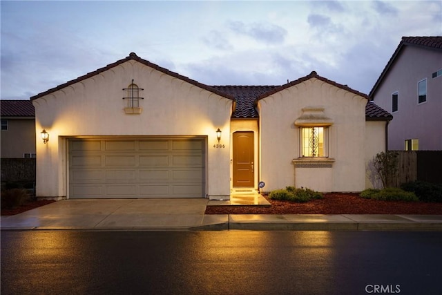 mediterranean / spanish-style house with a garage