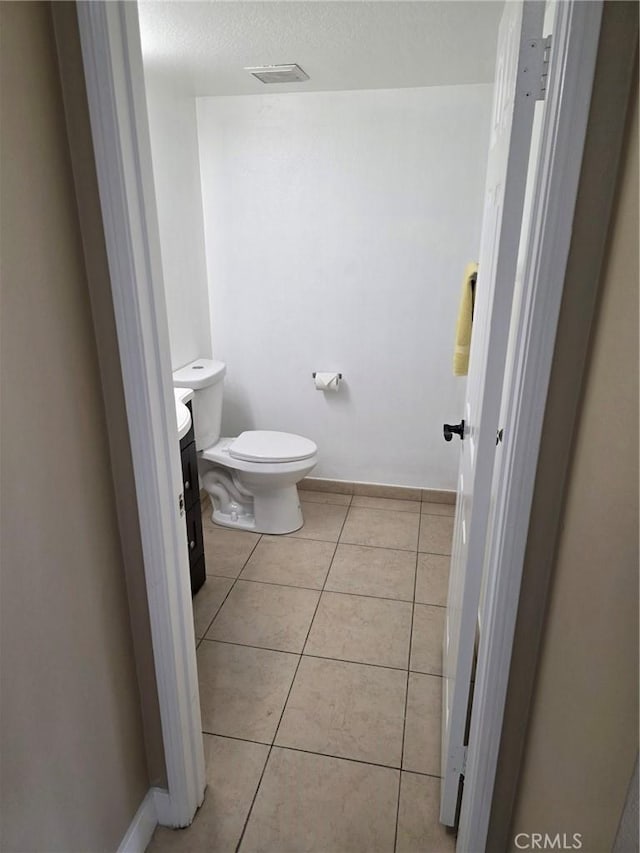 bathroom with tile patterned floors, a textured ceiling, and toilet