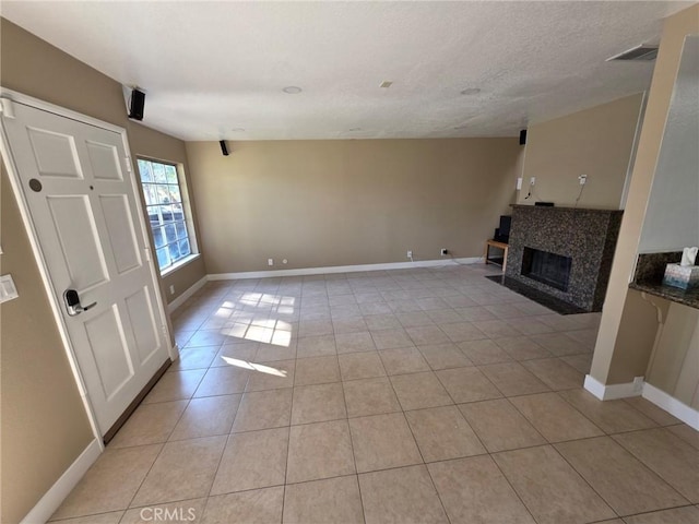 unfurnished living room with a textured ceiling and light tile patterned flooring