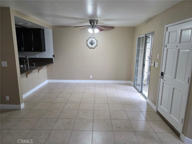 unfurnished dining area with light tile patterned floors, sink, and ceiling fan