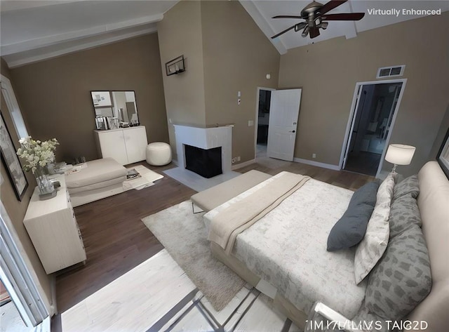 bedroom featuring hardwood / wood-style flooring, high vaulted ceiling, and a fireplace