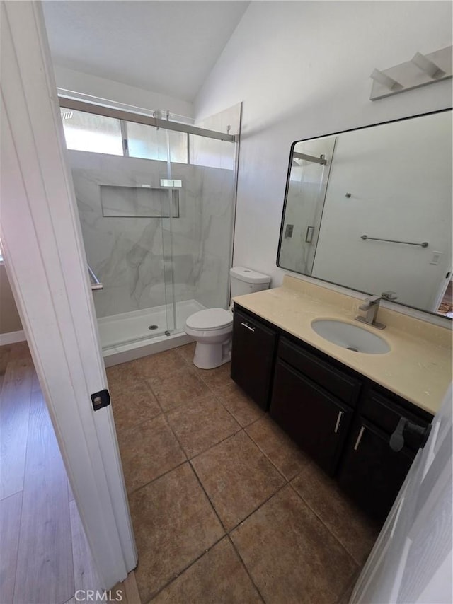 bathroom featuring lofted ceiling, vanity, toilet, and an enclosed shower