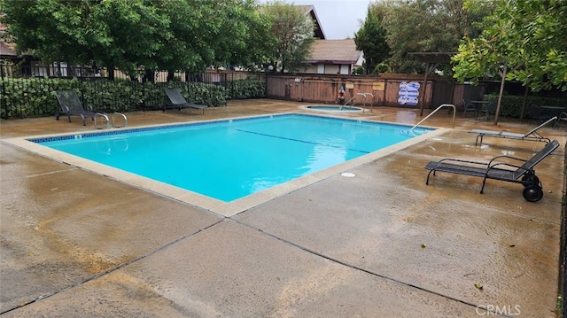 view of swimming pool featuring a community hot tub and a patio area