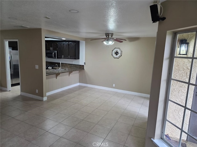 kitchen with ceiling fan, stainless steel appliances, kitchen peninsula, and a textured ceiling