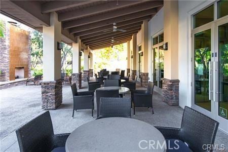 view of patio with ceiling fan and exterior fireplace